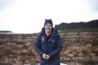 Duncan standing on a wetland