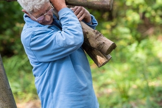 Man volunteers carrying logs Matthew Roberts