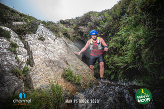 Man in helmet climbing out of a cave in Exmoor National Park