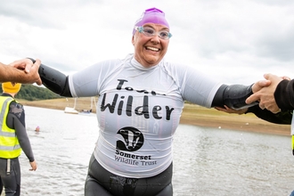 Team Wilder swimmer exiting the lake at the exmoor swim