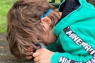 Child looking through hand lens