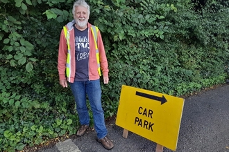 volunteer marshal ready to collect ticket money for a car park