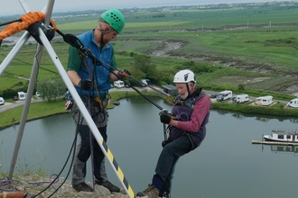 81 year old abseiling and taking his first step back off the top of the cliff