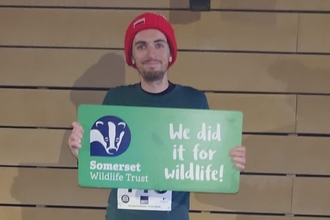 Runner holding "we did it for wildlife" sign