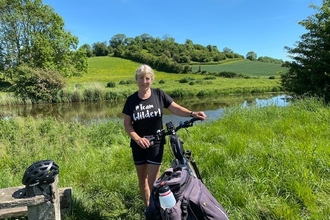 Cyclist stopping to post for photo infront of views across the somerset levels