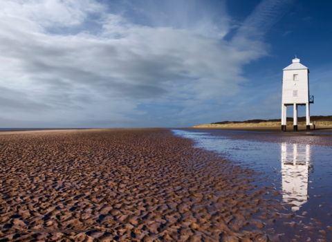 Landscape picture of Burnham-on-Sea beach on sunny day with lighthouse in background