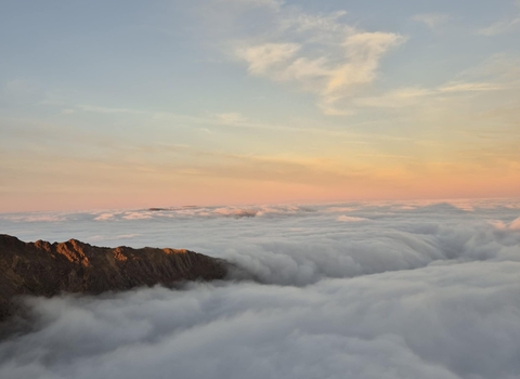 View overlooking the clouds at sunrise from the summit of Snowdon